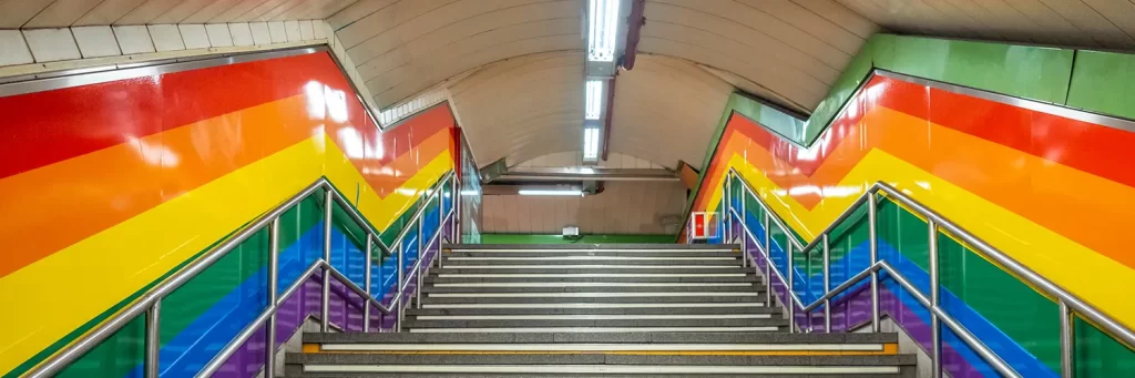 Subida metrô chueca, com paredes de arco iris.