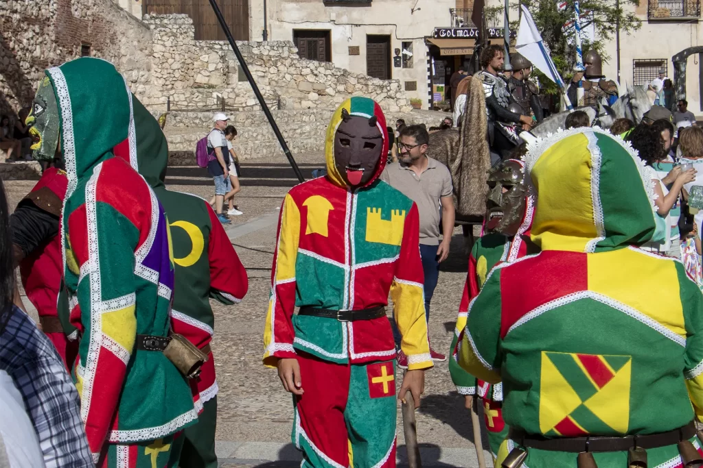 Participantes vestidos com trajes medievais coloridos e máscaras desfilam em um festival em Hita, Espanha.