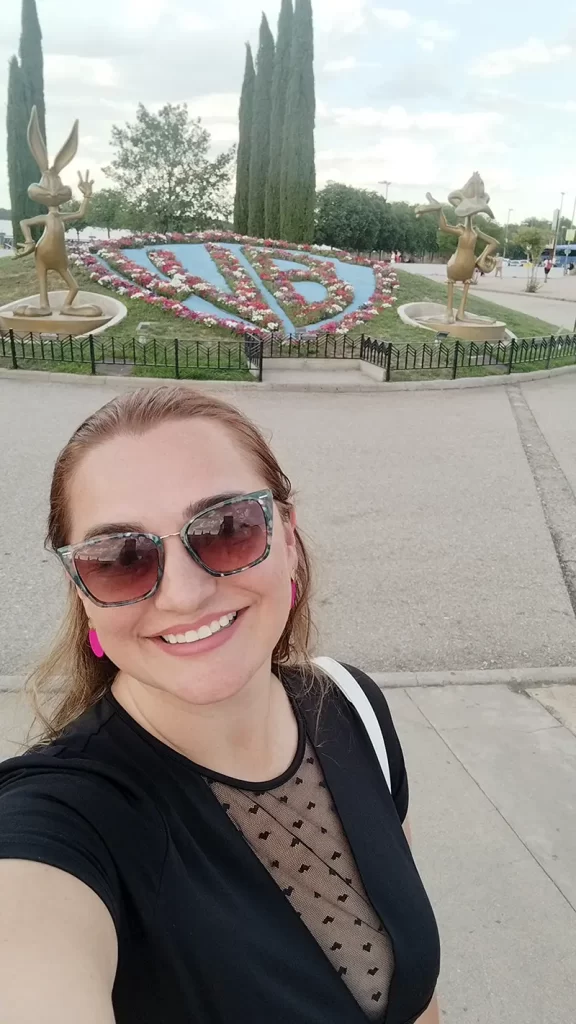 Selfie em frente ao jardim do Parque Warner Madrid, que apresenta estátuas douradas do Pernalonga e Patolino