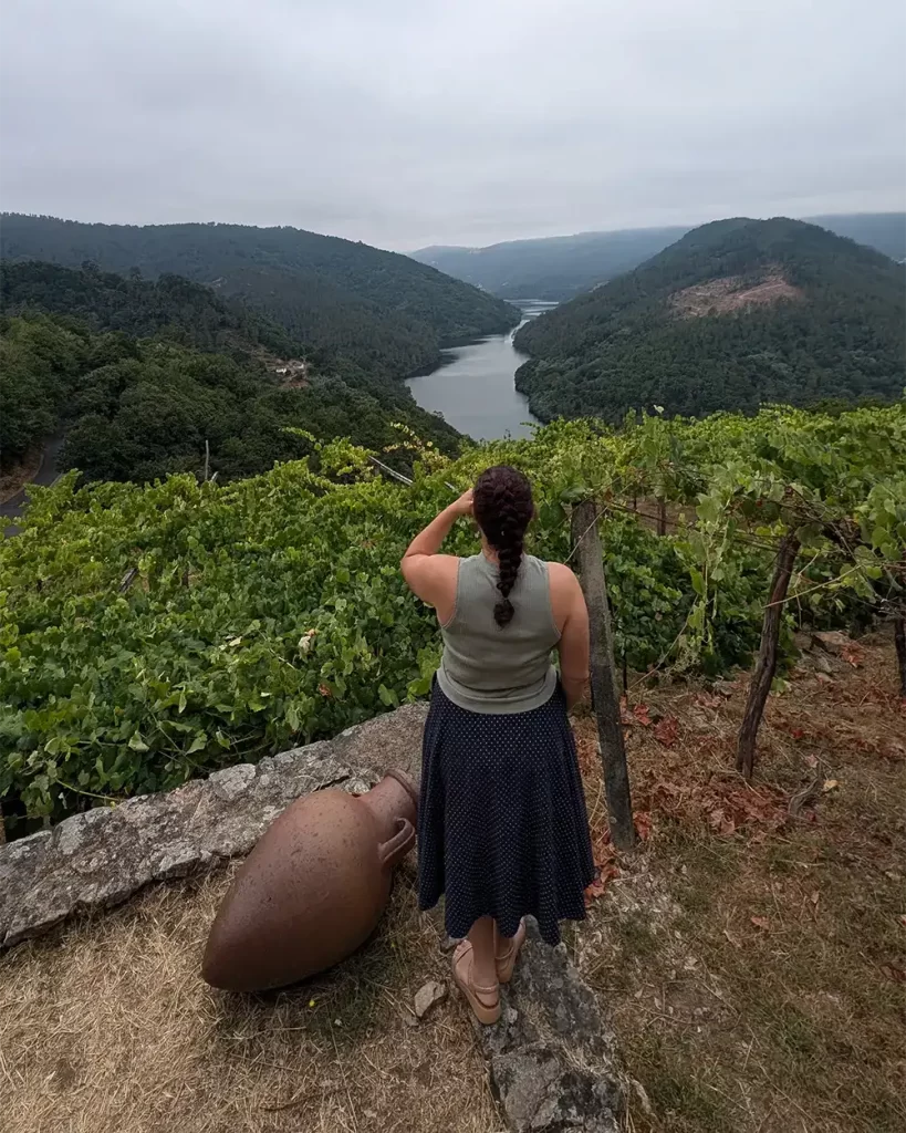 Mulher observando as vinhas da Adegas Moure com vista para o rio Sil.