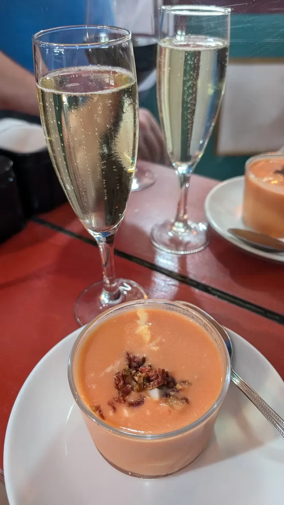 Um copo de gazpacho com um copo de cava.