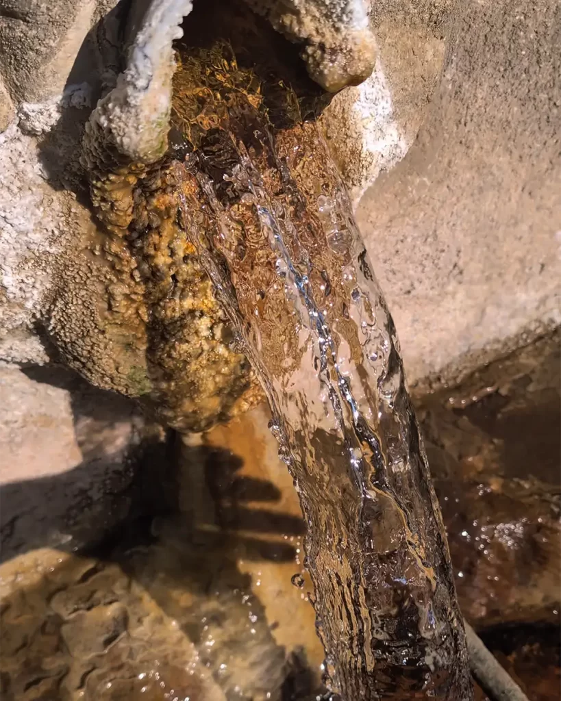 Água termal fluindo de uma fonte de pedra em As Burgas, Ourense.