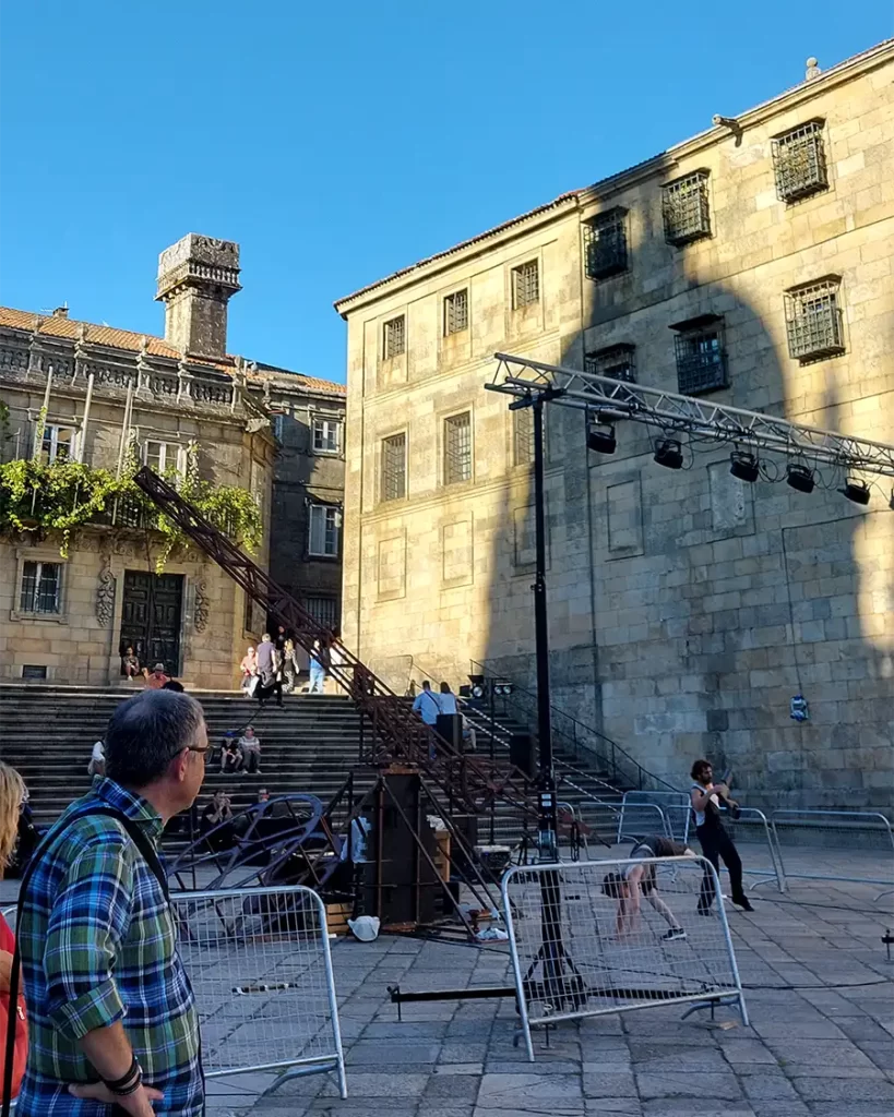 Escadaria e fachadas históricas na área do centro histórico de Santiago de Compostela, com estrutura montada para o festival de Teatro.