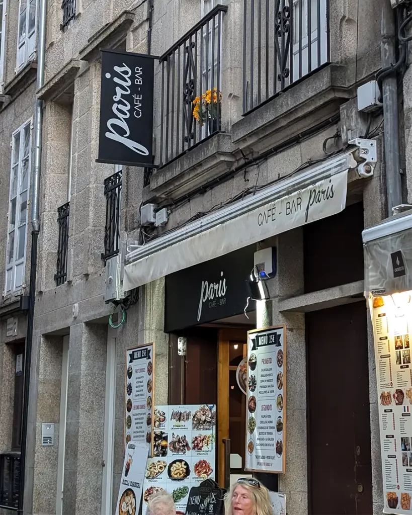 Fachada do Bar París, um dos pontos de partida da tradicional rota de bares 'Paris-Dakar' em Santiago de Compostela, com um cardápio exibido na entrada.