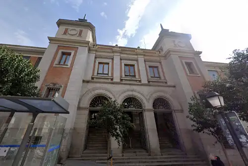 Fachada do Mercado de San Fernando, em Madrid, com arquitetura tradicional e entrada principal destacada por arcos e portas de vidro, refletindo a combinação de tradição e modernidade do local.