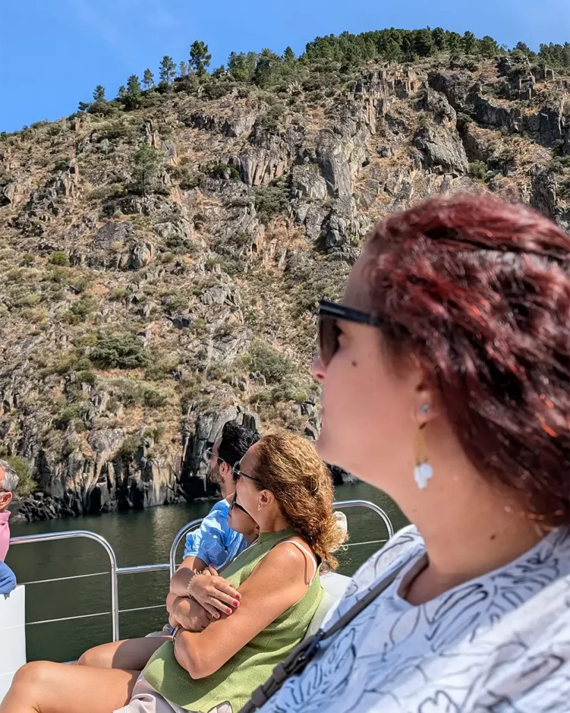 Passeio de barco pelo rio Sil, com foco em uma mulher admirando as escarpas rochosas da Ribeira Sacra.