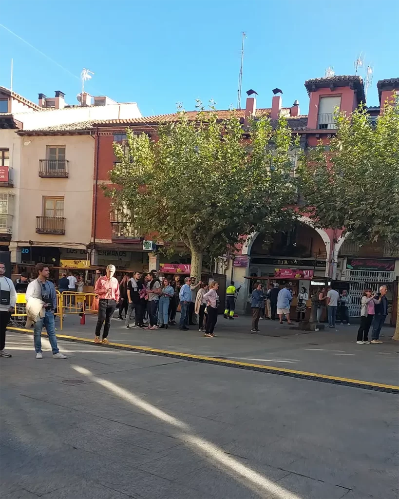 Pessoas aguardando na fila em uma praça movimentada em Ribera del Duero.