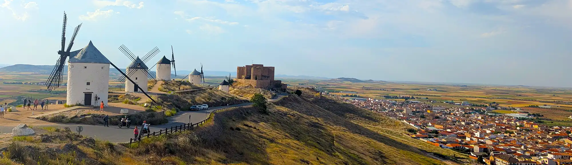 Moinhos de vento e castelo de Consuegra no alto do Cerro Calderico com vista para a cidade e as planícies de Castilla-La Mancha