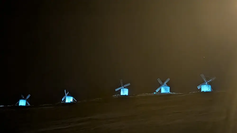 Moinhos de vento de Consuegra iluminados à noite com luz azul sobre o Cerro Calderico