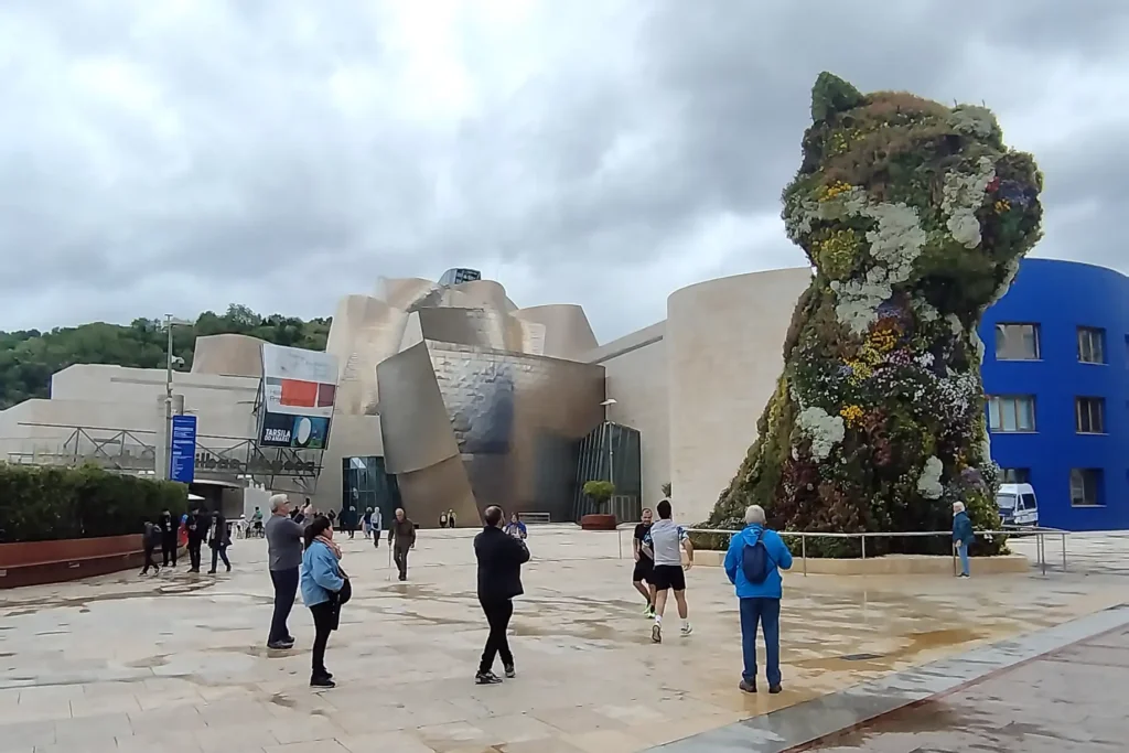 Fachada do Museu Guggenheim Bilbao com a escultura floral Puppy de Jeff Koons em destaque