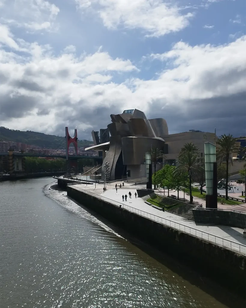 Vista do Museu Guggenheim Bilbao e da ponte La Salve às margens do rio Nervión em dia parcialmente nublado