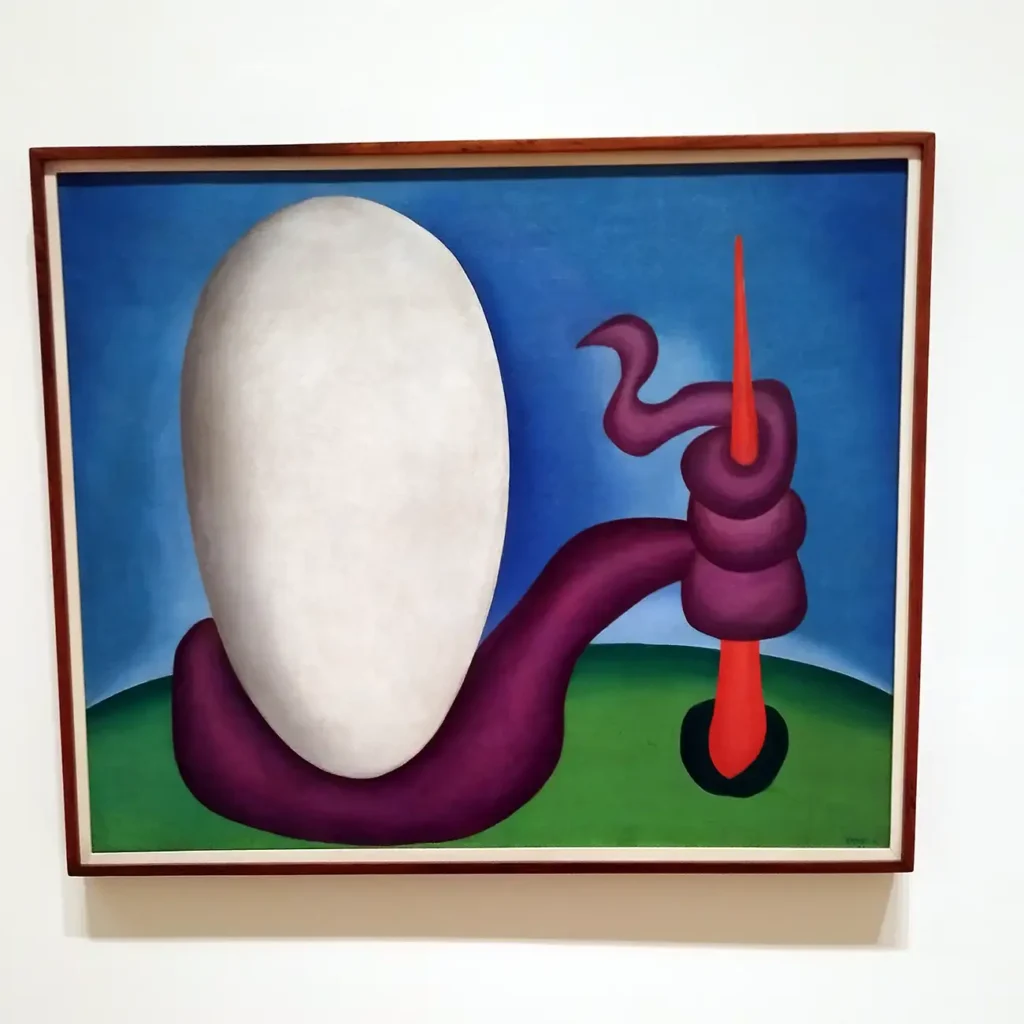 Obra O Ovo de Tarsila do Amaral com forma oval branca sobre fundo azul e campo verde no Guggenheim Bilbao