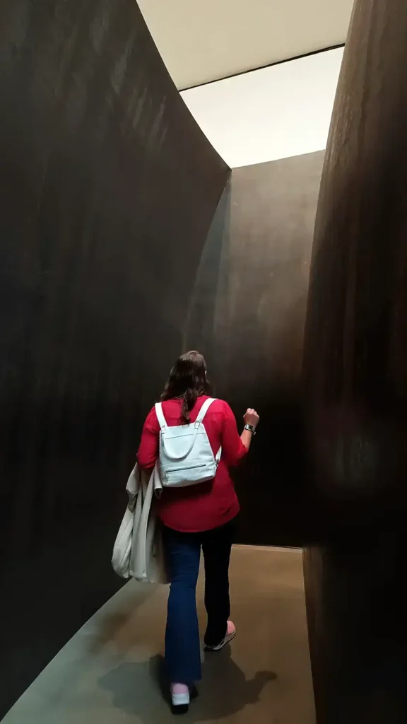 Visitante caminhando por dentro da escultura de aco da exposicao The Matter of Time no Guggenheim Bilbao