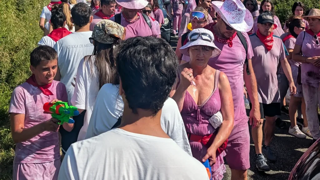 Pessoas celebram na Batalha de Vinho de Haro, com roupas brancas completamente manchadas pelo vinho roxo.