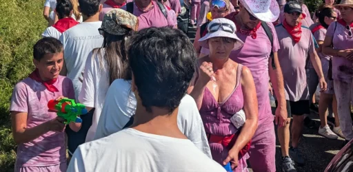 Pessoas celebram na Batalha de Vinho de Haro, com roupas brancas completamente manchadas pelo vinho roxo.
