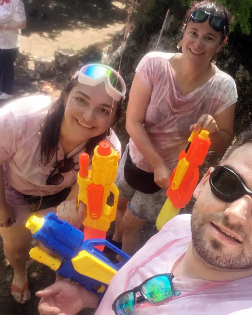 Grupo de personas con camisetas rosas sosteniendo pistolas de agua durante la Batalla del Vino de Haro