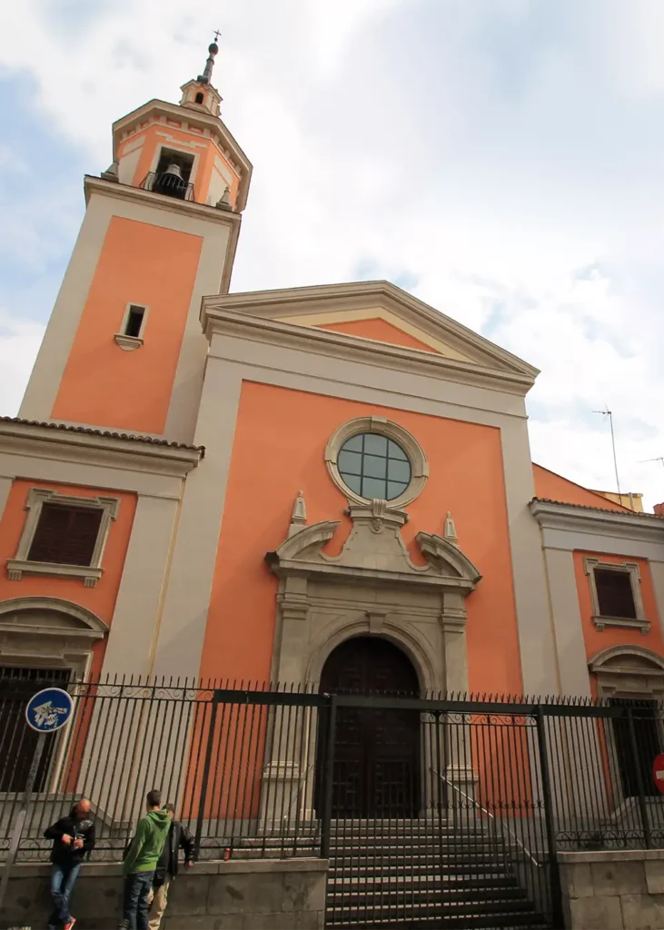 Fachada da Igreja de San Lorenzo, no bairro de Lavapiés em Madrid. A igreja, de cor salmão e com uma torre sineira, é o centro dos atos religiosos da festa.