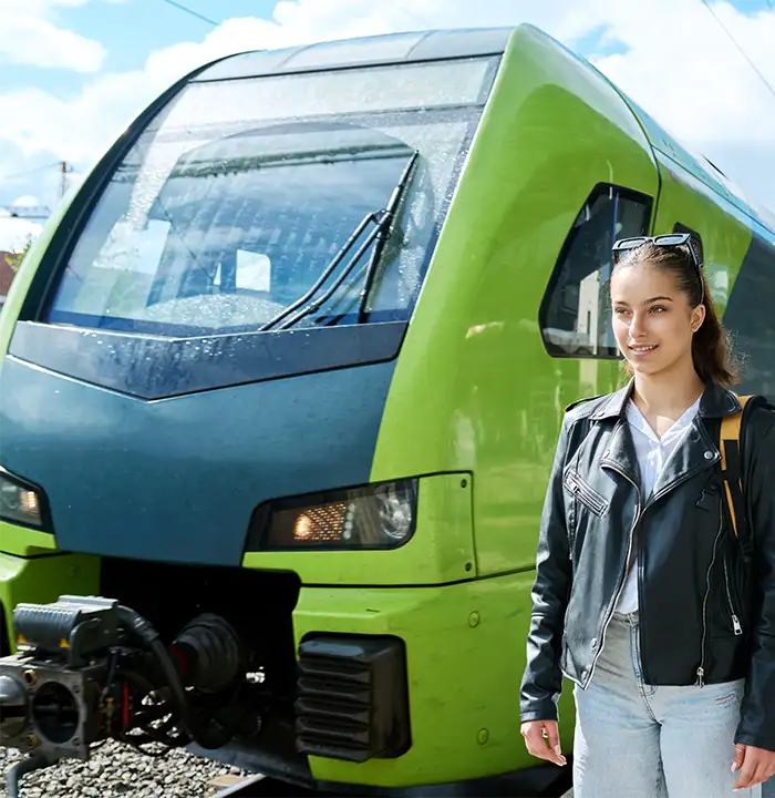 Jovem de pé ao lado do trem.