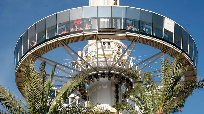 Visitantes na cabine de vidro da atração Infinito no Terra Mítica, a torre giratória que oferece vistas panorâmicas do parque e de Benidorm.