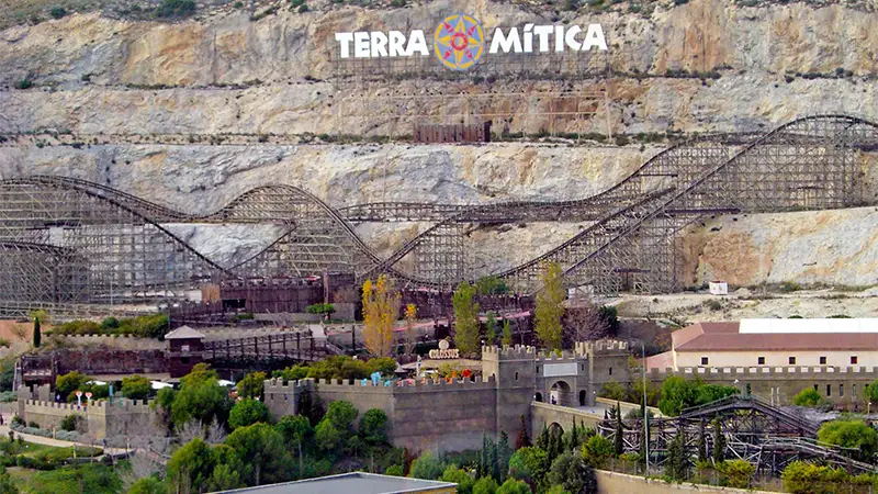 A imponente estrutura da Magnus Colossus, a antiga montanha-russa de madeira do Terra Mítica, que hoje decora a paisagem do parque.