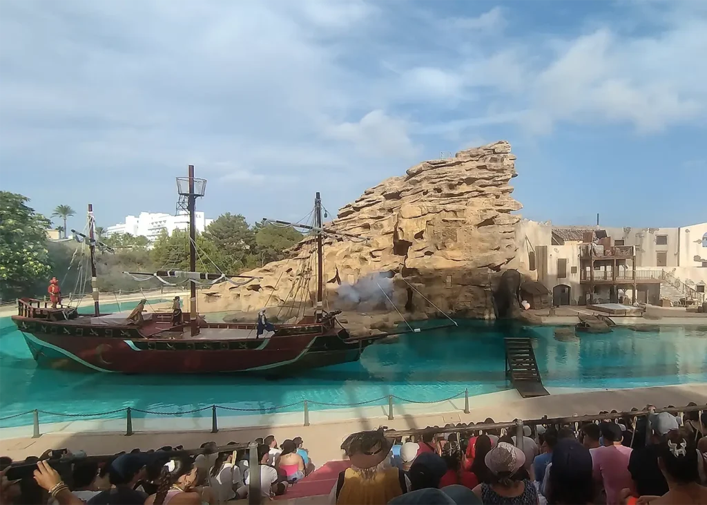 The pirate ship from the Barbarroja show at Terra Mítica, with a cannon firing during the performance on the large amphitheatre lake.