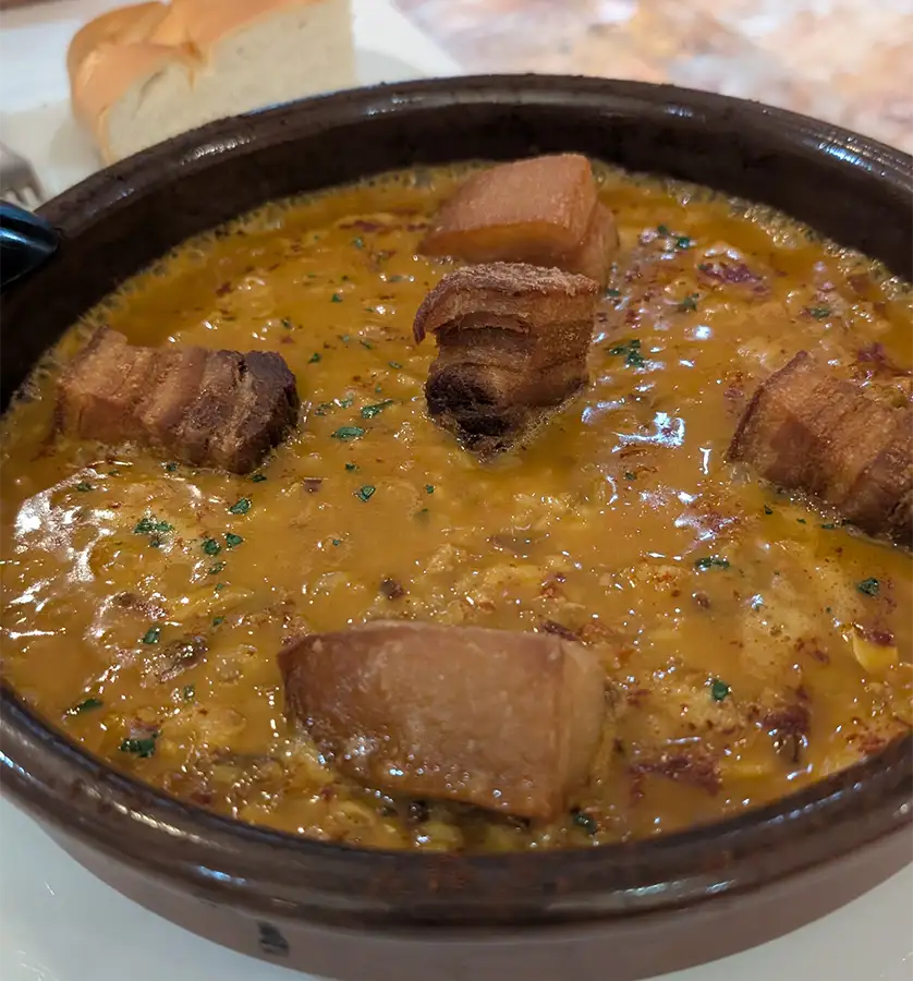 Arroz de Zamora em panela de barro com torresmo e salsa picada