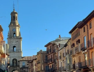 Vista da Torre do Relógio de Toro com edifícios antigos na praça principal, destacando a arquitetura histórica e o céu azul da cidade de Zamora.