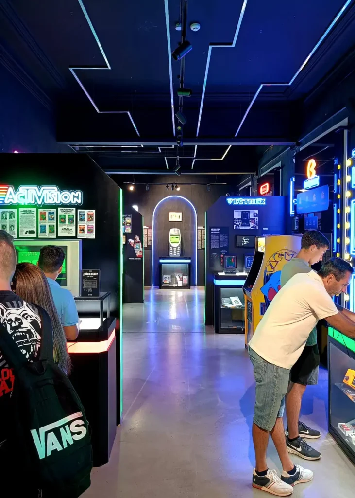 Visitantes jogando em máquinas de arcade no OXO Madrid, incluindo Street Fighter II, Mortal Kombat e Donkey Kong.