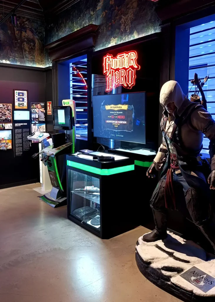 Área temática do Guitar Hero no OXO Madrid, com estátua de personagem de Assassin’s Creed ao lado.