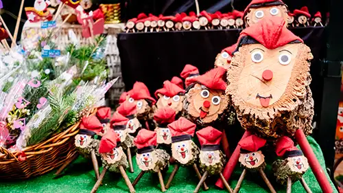Tió de Nadal feitas de troncos de madeira com rostos pintados