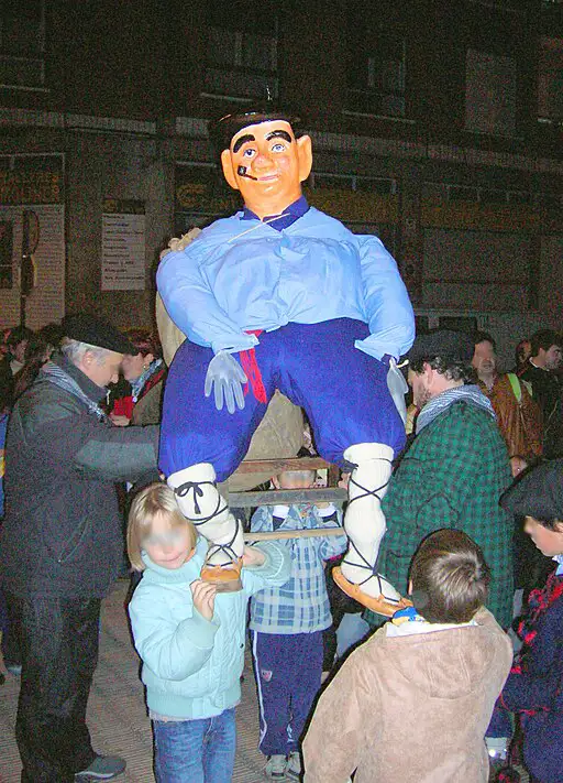 Boneco gigante tradicional do Olentzero carregado por adultos e crianças durante uma celebração de Natal no País Basco.