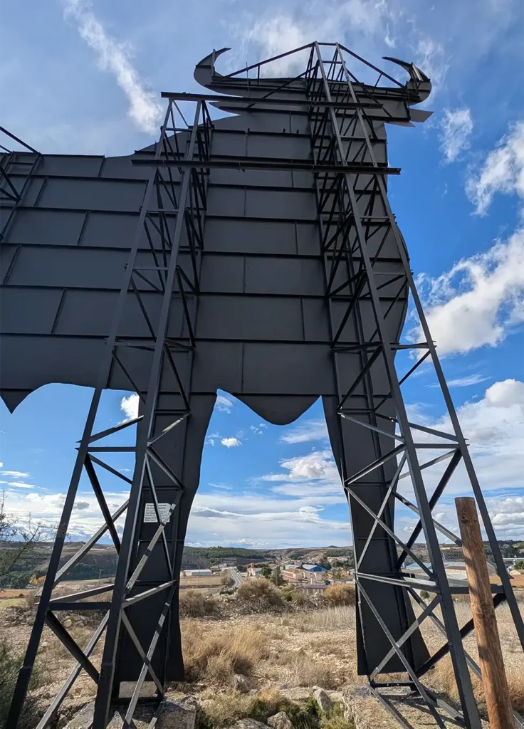 Estrutura metálica do Touro de Osborne vista por trás, mostrando a armação de aço e a paisagem rural dos Monegros ao fundo.