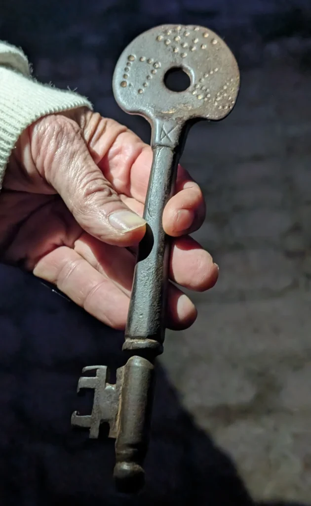 Chave antiga usada em adega, segurada na mão, associada às caves tradicionais de vinho no Penedès.