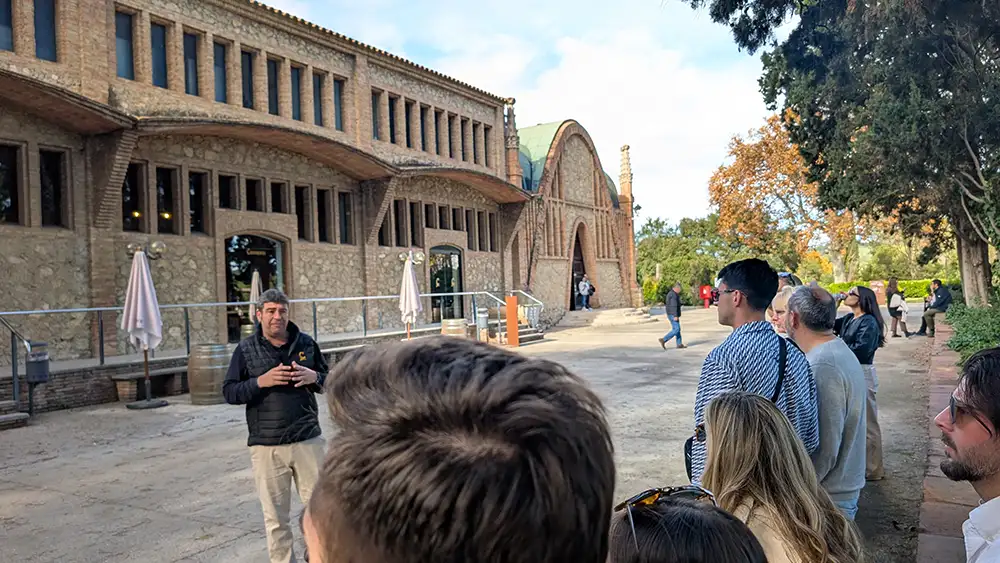 Visita guiada à Codorníu com grupo de visitantes em frente ao edifício modernista da vinícola