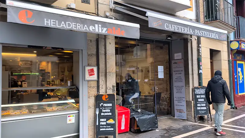 Fachada da Heladería Elizalde em Pamplona, com vitrine de produtos e acesso à cafeteria e pastelaria.