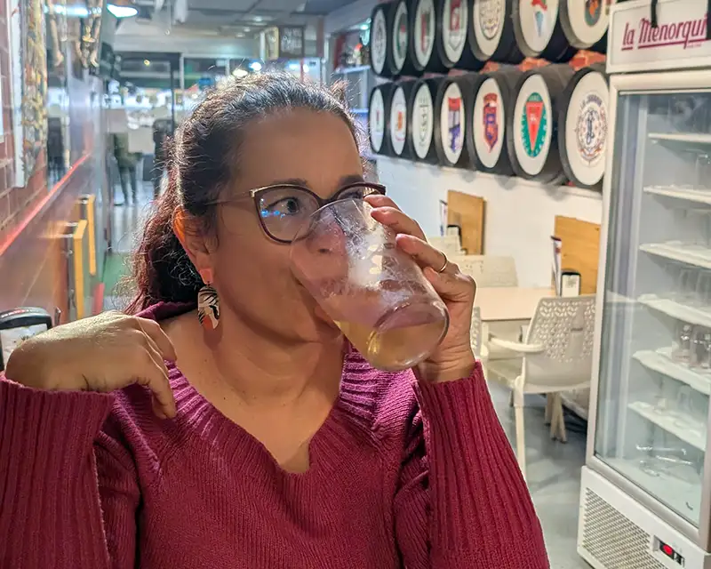 Pessoa bebendo vinho branco em um bar em Pamplona