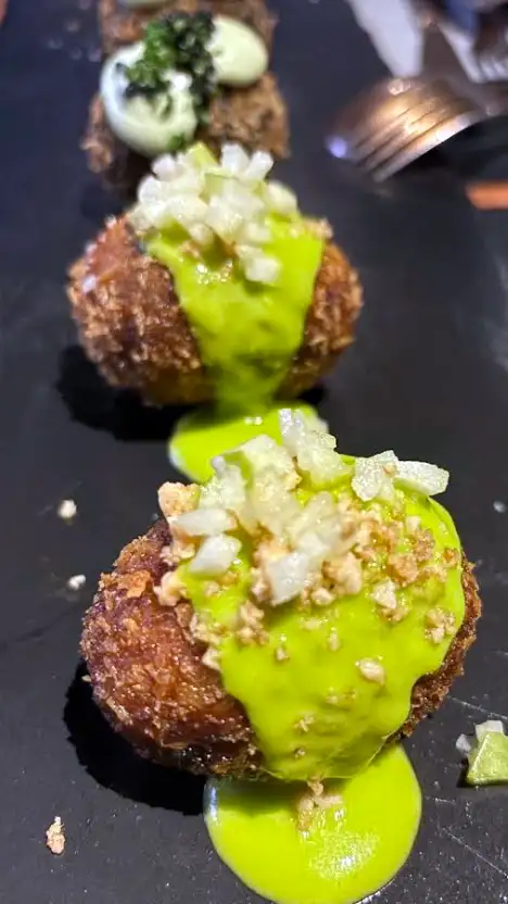 Croquetes servidos na Taberna El Botero em Toledo com molho verde e cebola picada por cima.
