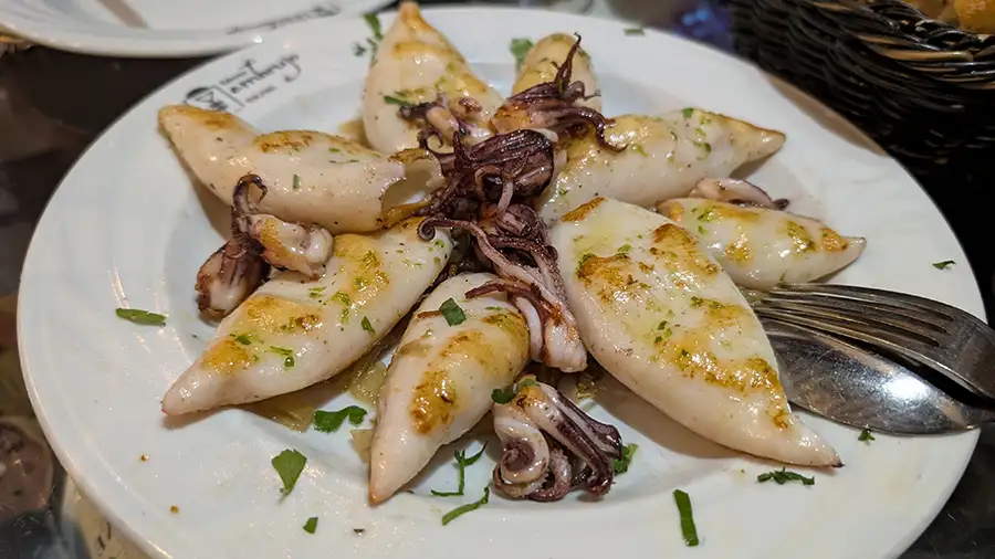 Lulas grelhadas servidas na Taberna Embrujo em Toledo, prato de tapas com azeite e salsinha.