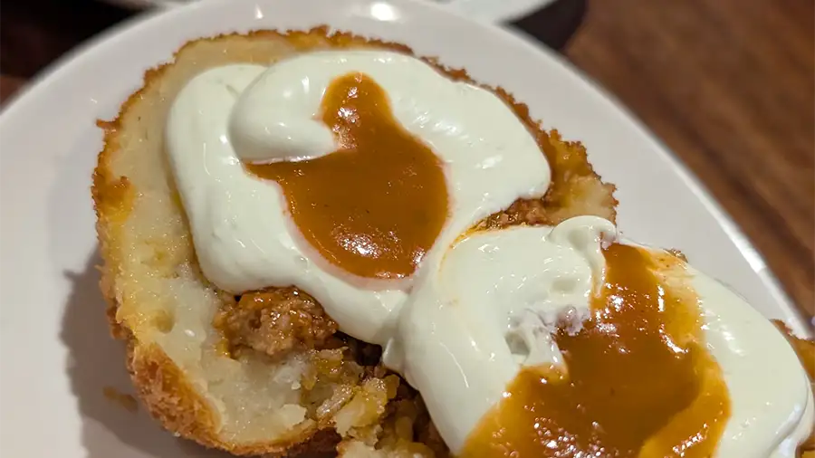 La Bomba servida no El Trébol em Toledo, tapa com batata, carne e ovo cremoso por cima.