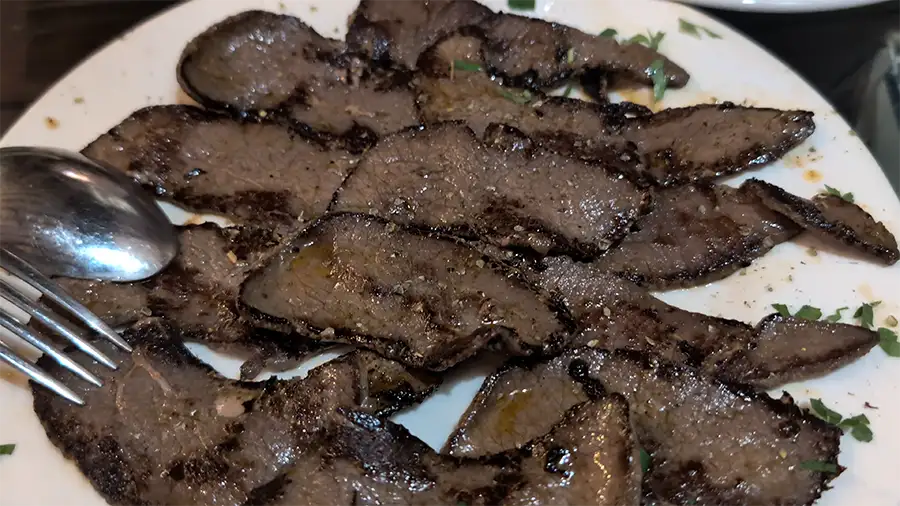 Fatias de venado grelhado servidas como tapa em Toledo, carne de caça típica da região de Castilla-La Mancha.