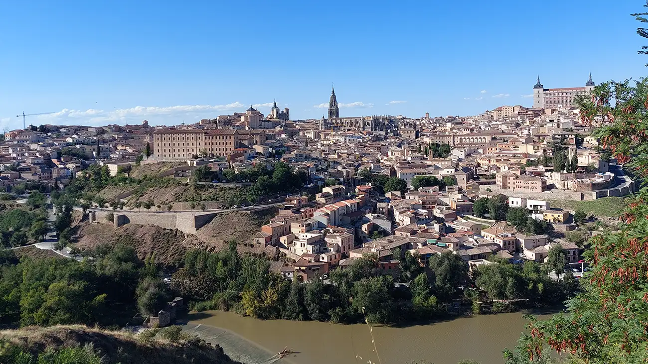 Vista panorâmica de Toledo com o rio Tejo em primeiro plano e a Catedral ao fundo no centro histórico.