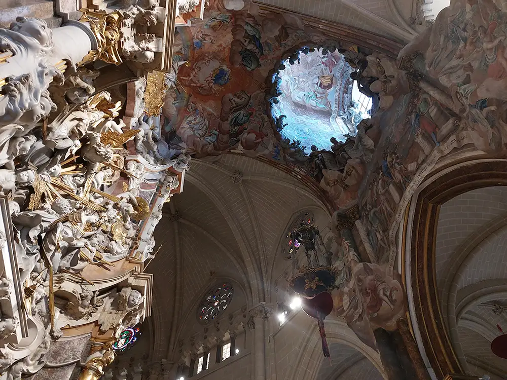 Cúpula e detalhes barrocos no interior da Catedral de Toledo com afrescos no teto.