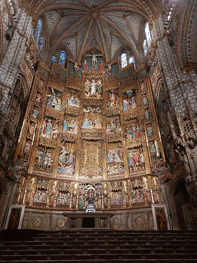 Altar-mor da Catedral de Toledo com retábulo dourado e esculturas religiosas.