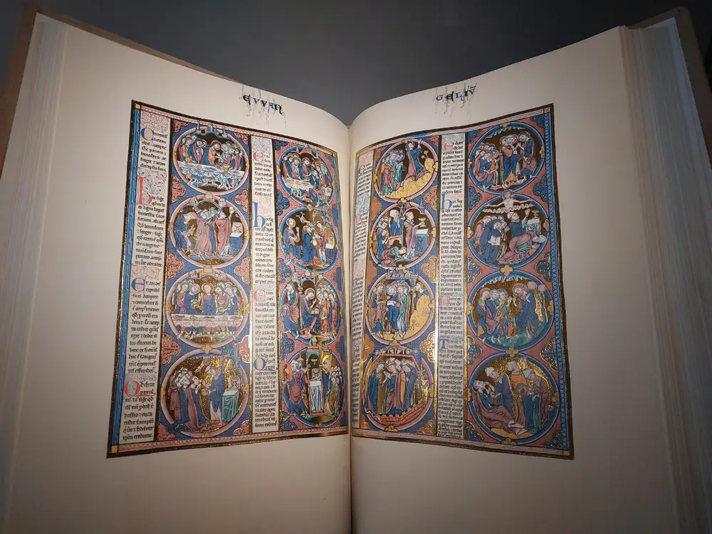 Livro medieval iluminado exposto no interior da Catedral de Toledo com miniaturas coloridas.
