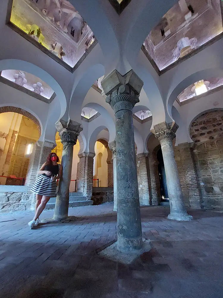 Interior da Mesquita do Cristo de la Luz em Toledo com arcos brancos e colunas de pedra.