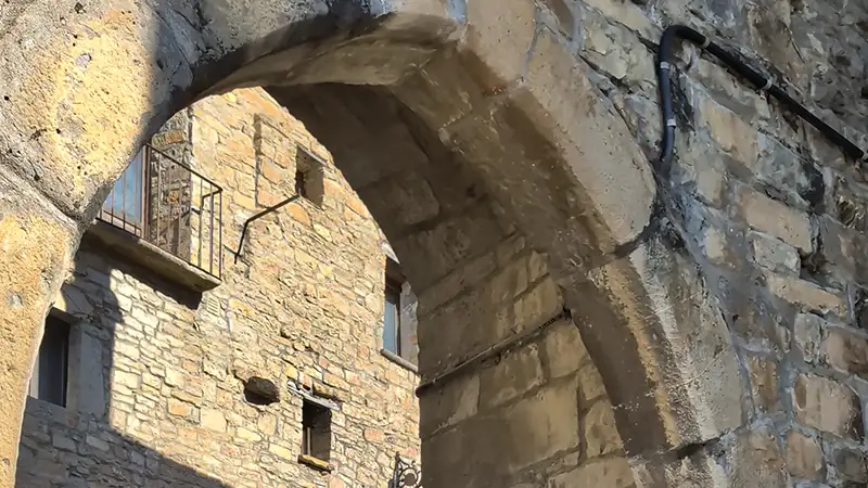 Casas de pedra do centro histórico de Aínsa com os Pirineus nevados ao fundo, Huesca, Aragão.