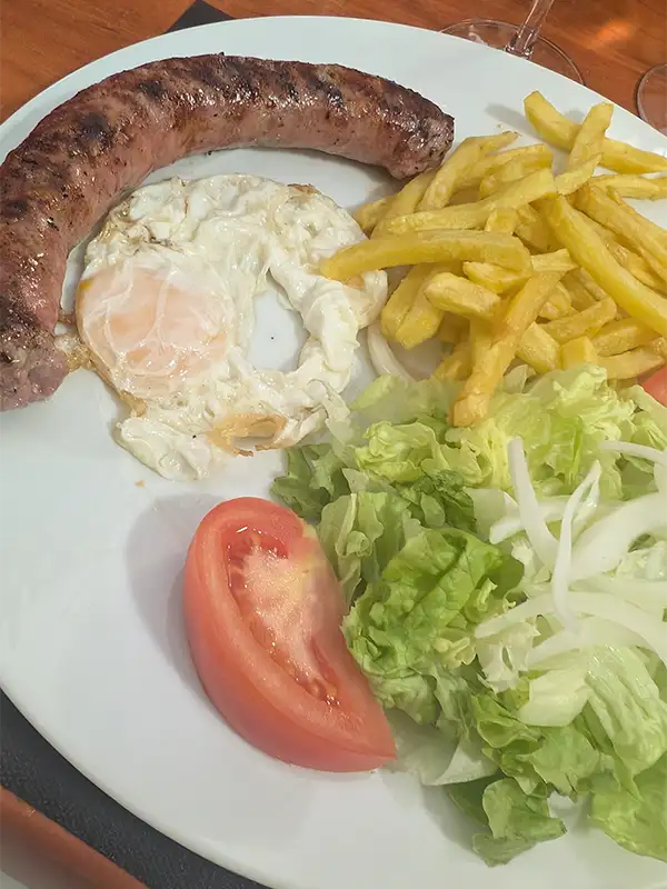 Prato com longaniza com ovo frito, salada e batatas do restaurante Jabonero
