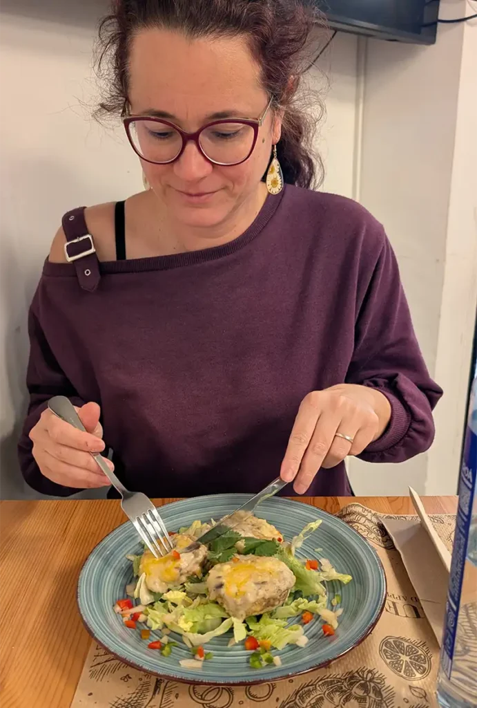 Mulher comendo cogumelos recheados no Restaurante Bar Abecé em Graus, Huesca.