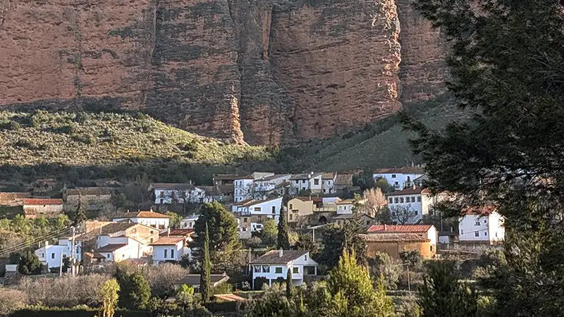 Vista do povoado de Riglos com as casas brancas e os mallos de rocha vermelha ao fundo, Huesca, Aragão.