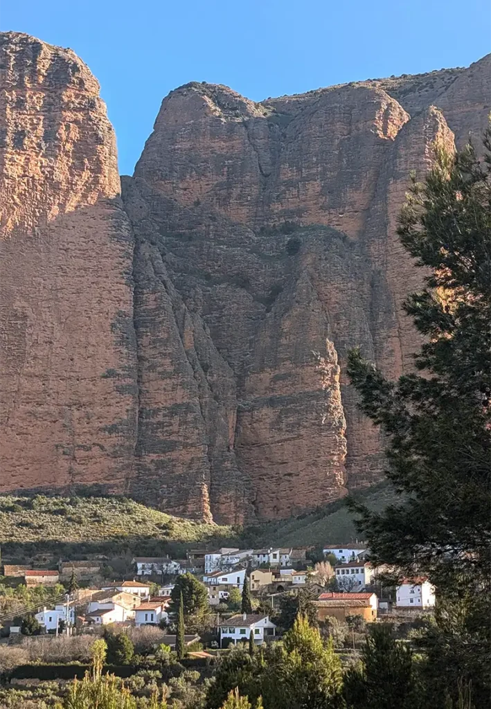 Vista panorâmica de Riglos com o povoado de casas brancas e os imponentes mallos de rocha vermelha ao fundo, Huesca, Aragão.
